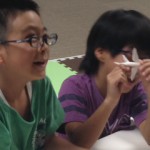 マシンから出てきたものを触って確認する子供たち