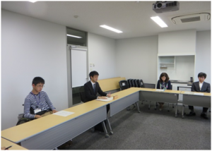 最終日の報告会の様子 （左：河田さん、左から２番目　担任の佐々木教諭）